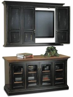 an entertainment center with black cabinets and a mirror on the wall over it's doors