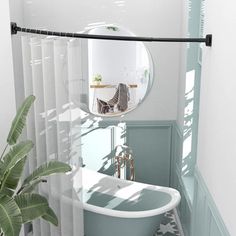 a bath tub sitting under a bathroom mirror next to a potted palm tree in front of it