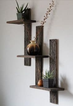 three wooden shelves with plants and vases on them hanging from the wall in front of a white wall