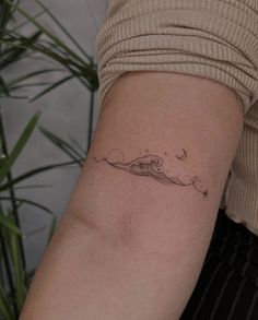 a woman with a small wave tattoo on her arm