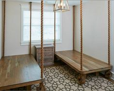 an empty room with two wooden benches and a hanging rope bed in the corner, next to a window