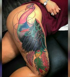 a woman's thigh with a colorful bird tattoo on her leg and the bottom half of her thighs