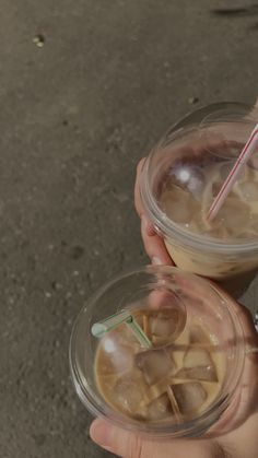 two people holding drinks in their hands with straws sticking out of the top one