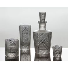 three black and white vases sitting next to each other on top of a table