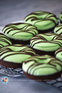 chocolate and green frosted donuts on a cooling rack