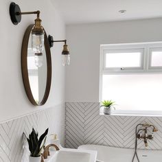 a bathroom with two sinks and a large mirror above the bathtub is decorated in herringbone tile