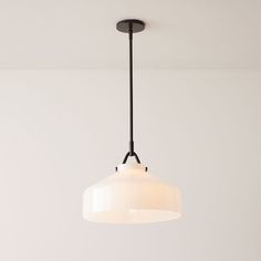 a white light hanging from a ceiling fixture in a room with no one around it