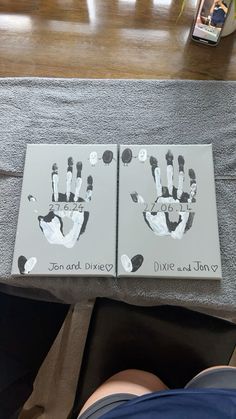 two books with hand prints on them are sitting on a table next to someone's feet