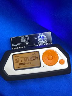 an orange and white electronic device sitting on top of a blue cloth