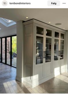 a kitchen with white cabinets and glass doors