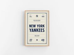 the new york yankees poster is displayed on a white wall in front of a wooden frame