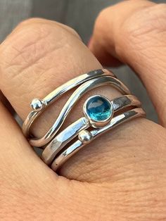 This silver stack ring is made up of four Sterling Silver rings which  sit together. There are two silver 'bubble' rings, a wave ring and a fourth ring featuring a 5mm London Blue Topaz.  Please let me know the size you require at Checkout. Also if possible please let me know whether you used a narrow ring sizer (approx: 4mm wide) or a wide ring sizer (approx: 6mm wide). This ensures a perfect fit. Wavey Ring, Silver Ring Ideas, Silver Ring Stack, Bubble Rings, Silversmithing Jewelry, Wide Silver Ring, Handmade Silver Jewellery, Sea Jewelry, Sterling Silver Jewelry Rings