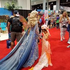 two women dressed as tinkerbells on the red carpet in front of people