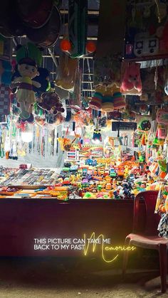 a chair sitting in front of a store filled with balloons and other things hanging from the ceiling