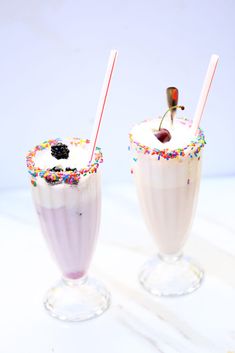 two milkshakes with sprinkles and cherry on top