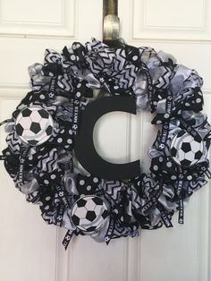 a black and white soccer wreath with the letter c hanging on it's front door