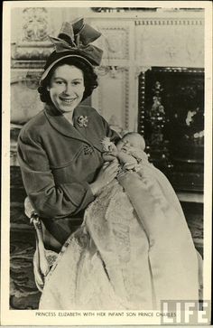 an old black and white photo of a woman holding a baby