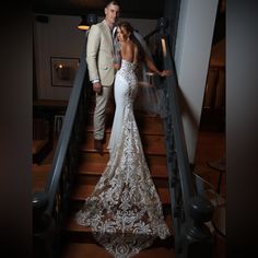 a bride and groom standing on the stairs at their wedding reception in an elegant dress