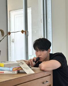 a person sitting at a desk with books and a cell phone