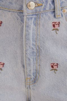 the jeans are embroidered with roses on them