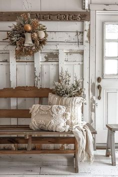 a wooden bench sitting in front of a white door with a wreath on top of it