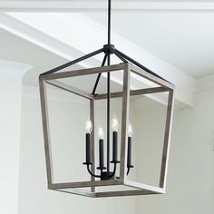 a light fixture hanging from the ceiling in a room with white walls and flooring