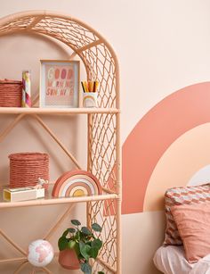 a bedroom with pink and orange decor on the walls, bookshelf in the corner