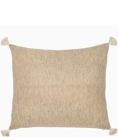 a beige pillow with tassels on the front and back, against a white background