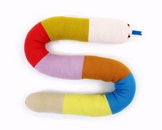 a colorful stuffed animal snake sitting on top of a white surface