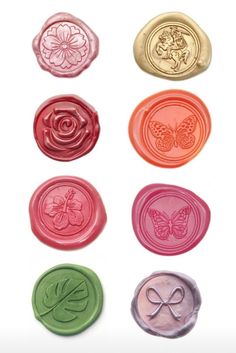 six wax seals with different designs and colors on them, including one for the butterfly