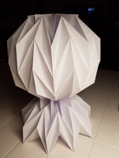 an origami sculpture sitting on top of a tiled floor