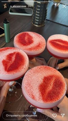 three glasses filled with red liquid sitting on top of a table next to each other