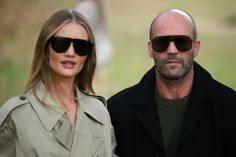 a man and woman wearing sunglasses standing next to each other