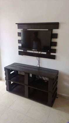 a flat screen tv sitting on top of a wooden entertainment center next to a window