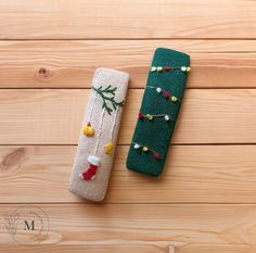 two christmas decorations are sitting on a wooden surface