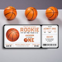 three basketballs and two ticket cards on a table with one ball in the air