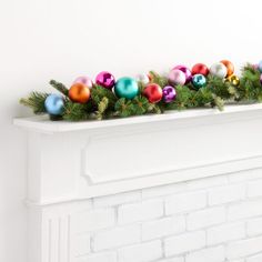 a white fireplace mantel with christmas decorations and garland on it's mantles