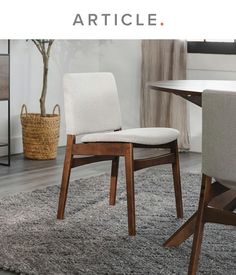 a dining room table with two chairs and a rug on the floor