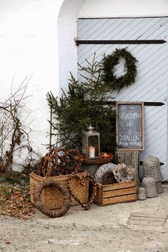 christmas decorations and wreaths are on display in front of a white building with an arched window