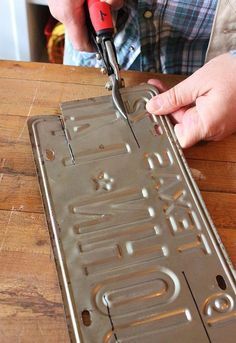 a person using a pair of pliers to cut out letters on a cookie sheet