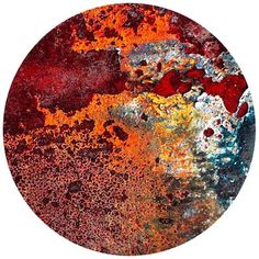 an orange and red circular painting with lots of paint splattered on it's surface