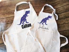 two personalized aprons with the word cotton and an image of a dinosaur on them