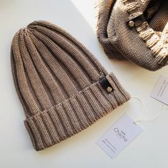 a hat and tag sitting next to each other on a white surface with the label attached