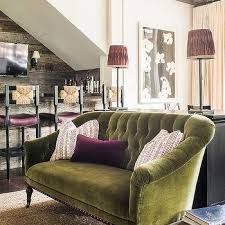 a living room filled with furniture next to a stair case covered in bookshelves