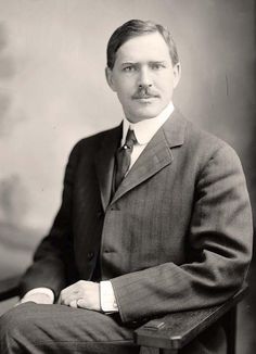 an old black and white photo of a man in a suit with a moustache