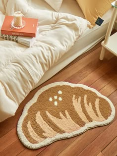 a brown and white cat rug on the floor next to a bed with pillows in it