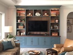 a living room filled with furniture and a flat screen tv on top of a wooden entertainment center