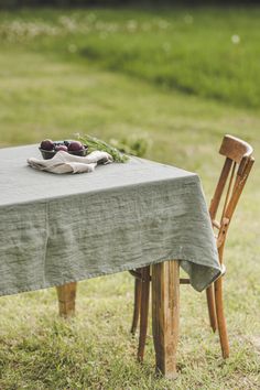 an empty table and chair in the grass