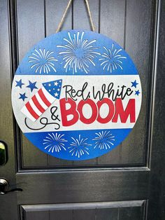 a red, white and boom door hanger on a black door with fireworks in the background