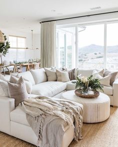 a living room filled with furniture and a large window next to a table covered in flowers